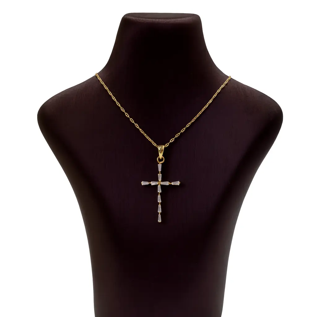 A yellow gold cross pendant on a stand
