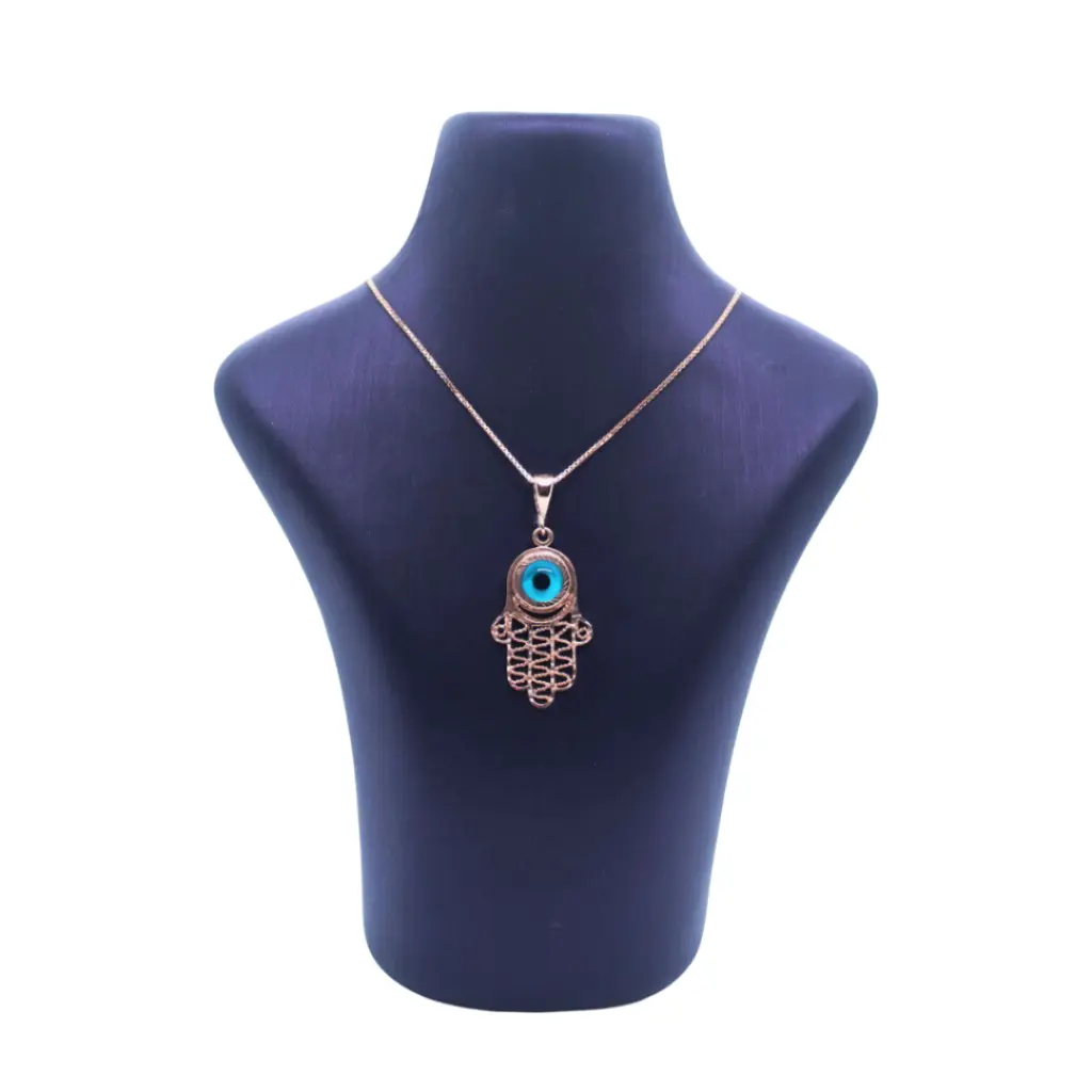 A yellow gold Hamsa pendant on a stand